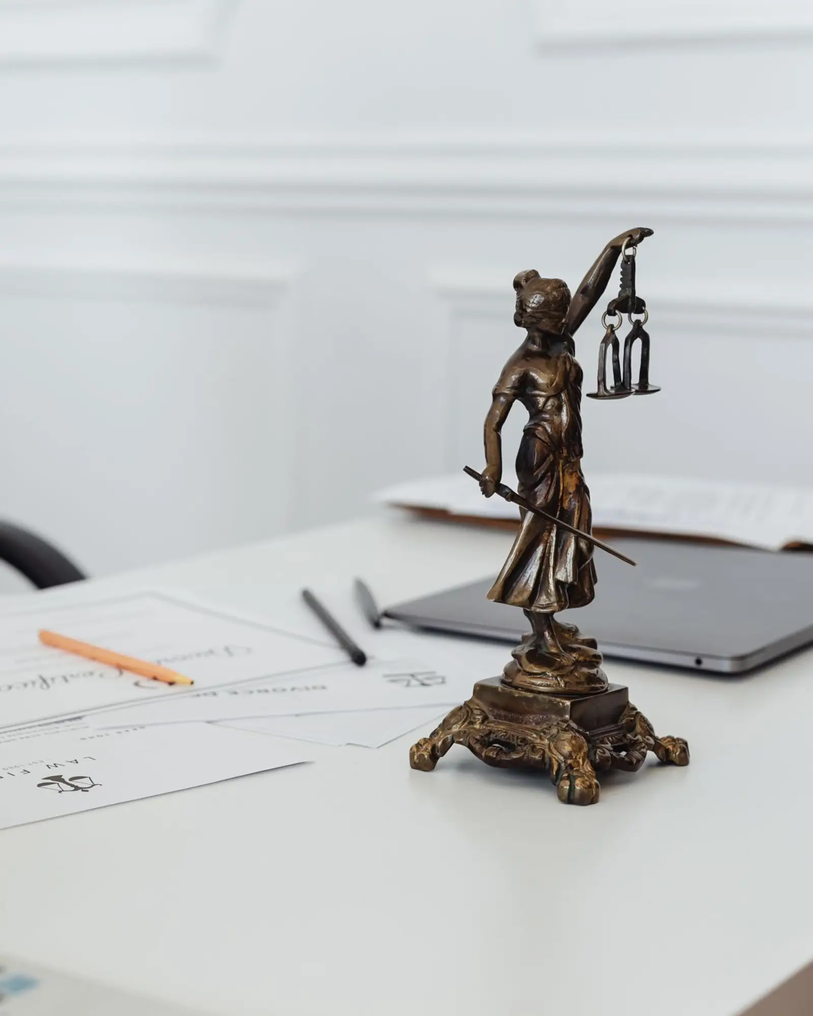 Legal documents and a statue of Lady Justice on an advocate's desk